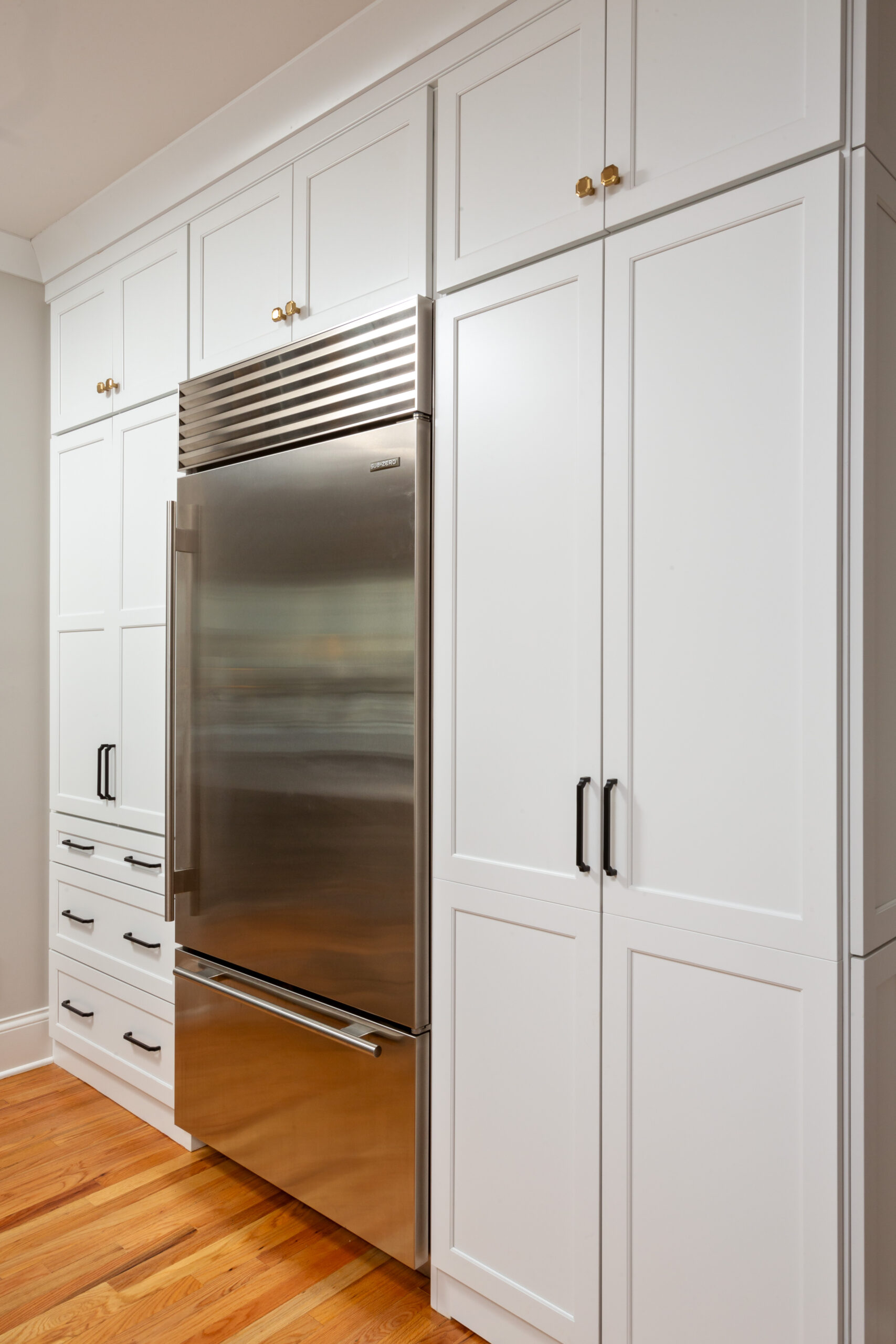 Floor-to-ceiling white shaker cabinets with built-in stainless steel refrigerator in Niskayuna kitchen remodel.